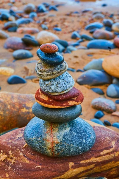 Kamienna kairnia z kolorowymi kamieniami i pomarańczową plażą — Zdjęcie stockowe