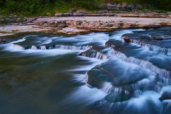 Gevallen bladeren in de Cataract Falls in de zomer met een groen bos en stromende rivier — Stockfoto