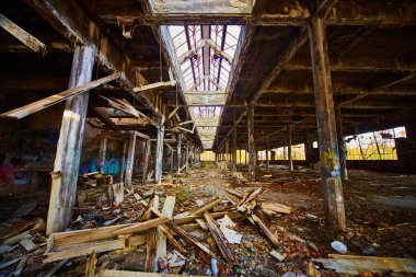 Çatı, destek kirişleri ve duvar yazıları kırılmış terk edilmiş ve çürümüş bir bina.