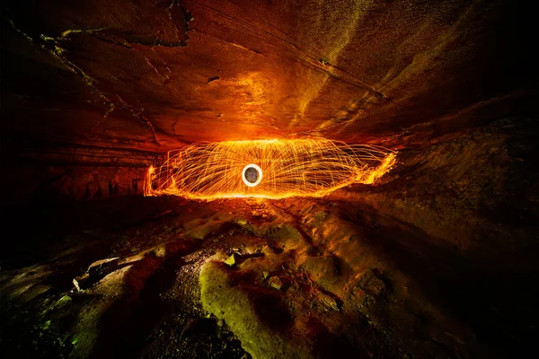 Пожежний купол і кільце помаранчевих іскр всередині широкої, але вузької печери з гладкою стелею і бурхливою підлогою — стокове фото