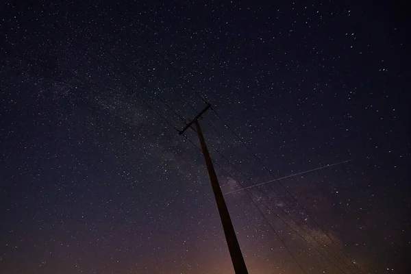 Hvězdná noční obloha a silueta telefonního sloupu v noci — Stock fotografie