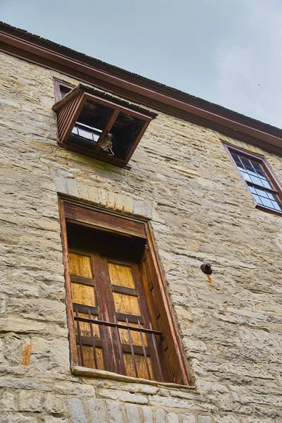 Stary kamienny budynek z podwójnym drewnianym ogrodzeniem w drzwiach i dźwigiem do dostawy — Zdjęcie stockowe