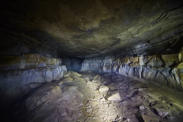 Ominous and dark tunnel inside a smooth roofed cave — Stock Photo, Image