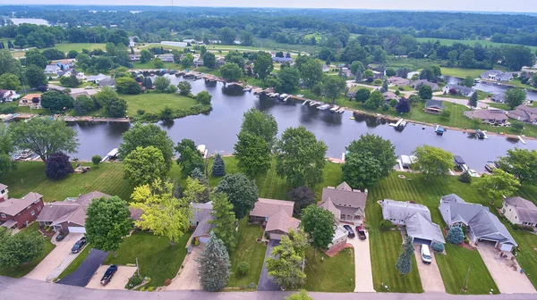 Aerial of lake in the country lined with lake houses and boats on docks — Stock Photo, Image