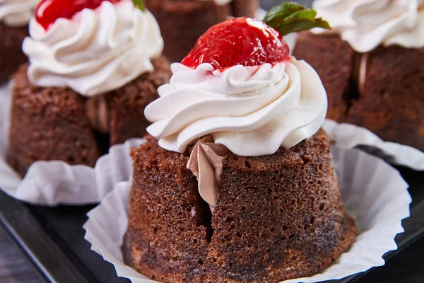Detalhe do delicioso cupcake de padaria cheio de cobertura e coberto com cereja — Fotografia de Stock