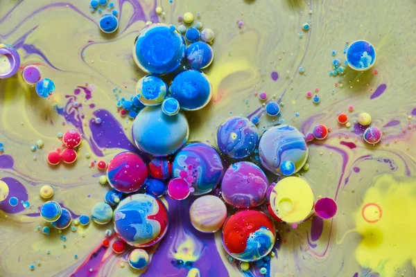 Colorful orbs floating on purple and yellow silky surface — Stock Photo, Image