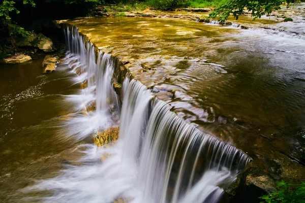 Fridfulla vattenfall gränsar på nära håll och rinner ut i grunda floder — Stockfoto