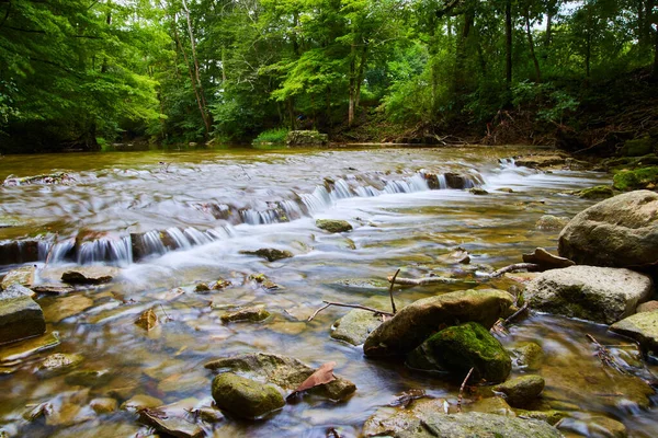 Schlechte Sicht auf den Fluss mit kleinen Wasserfällen und bemoosten Felsen — Stockfoto