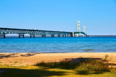 Michigan Gölü üzerinde dalgalı dalgalar ve kumlu plajlı dev asma köprü.