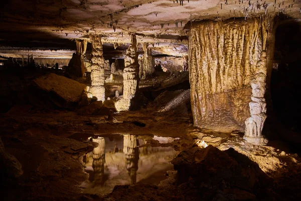Odbijające się wody pary stalagmitów w majestatycznym krajobrazie jaskini — Zdjęcie stockowe