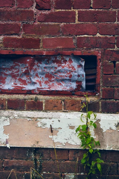 Edificio abbandonato primo piano del muro di mattoni rossi con fori e vernice peeling — Foto Stock