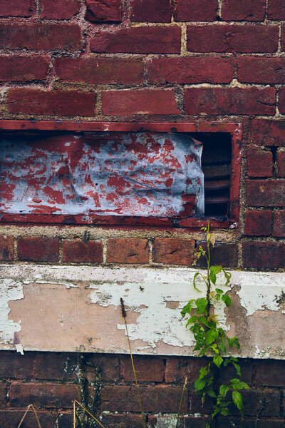 Abandoned building close-up of red brick wall with holes and peeling paint