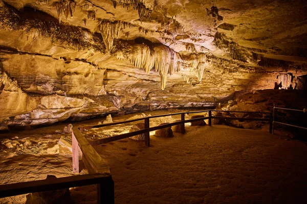 Jaskiniowy szlak spacerowy z drewnianym płotem obok stalagmitów i stalaktytów — Zdjęcie stockowe
