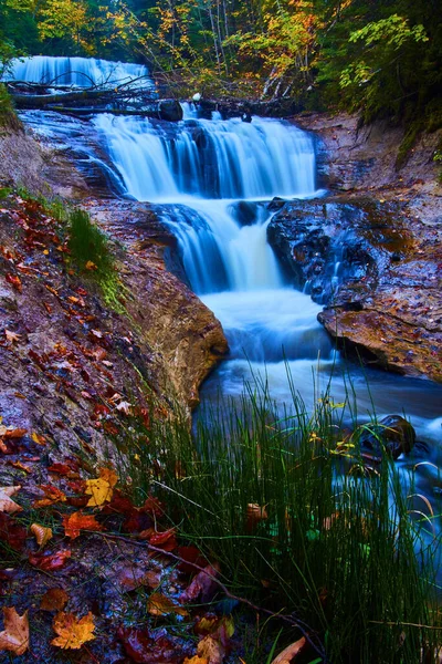 Чотириярусний водоспад з осіннім листям на стінах скель — стокове фото