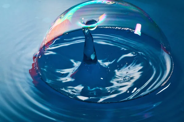 Kék felület és buborék, ahogy a vízcsepp majdnem buborékba törik, hogy ütközzen egy másik vízfolyással. — Stock Fotó