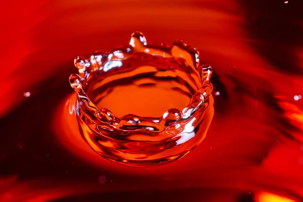Karmínově červená a oranžová koruna vody vytvořená z kapky vody — Stock fotografie