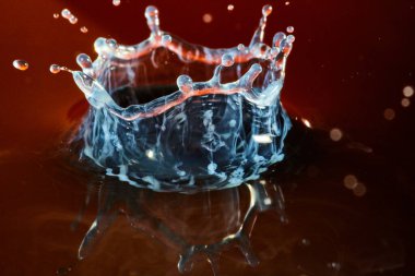 Kırmızı su arka planlı hayalet gibi beyaz bir su halkası.