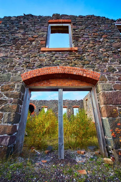 Katteeton hylätty rakennus punainen kivi tiili ja monivärinen kivitalo puuttuva ikkuna yläpuolella pariovi paikka — kuvapankkivalokuva