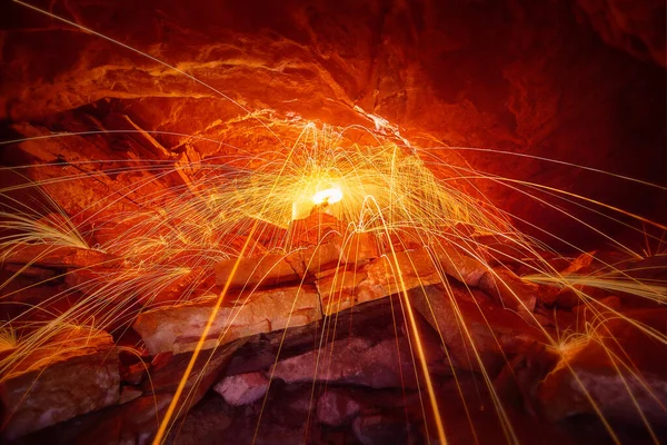 Lluvia de chispas sobre piedras dentro de una cueva y con un anillo amarillo de luz — Foto de Stock