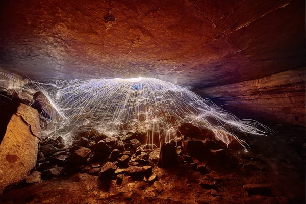 White steel wool sparks illuminating cave exit — Stock Photo, Image