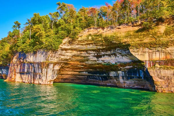 Pictured Rocks with teal and green waters around multicolored cliff wall — Stock Photo, Image