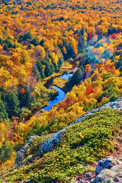 Fall forest has blue river snaking through it and a mossy rock overlooking it — Stock Photo, Image