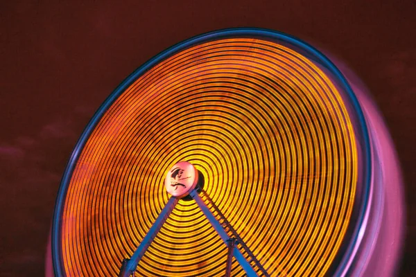 Roda gigante amarela girando à noite em infravermelho em um carnaval ou feira — Fotografia de Stock