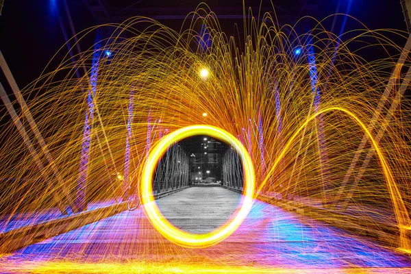 stock image Black and white middle portal with a yellow circle of sparks on a bridge at night