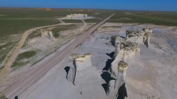 Aerial ao longo de formações rochosas do deserto por estrada em Kansas — Vídeo de Stock
