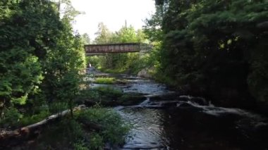 Ormanda çağlayan şelalelerin üzerinden geçen demiryolu köprüsünden geriye doğru.