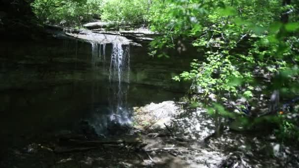 Cachoeira que flui sobre a borda do penhasco na floresta — Vídeo de Stock