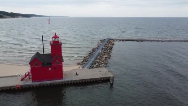 Antenne rund um den roten Leuchtturm am See in Michigan mit Fluss und Stadt im Hintergrund — Stockvideo