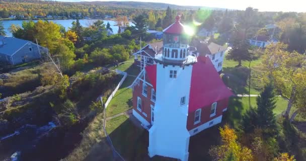 Aérea del faro rojo y blanco de Eagle Harbor en los lagos de Michigan — Vídeos de Stock
