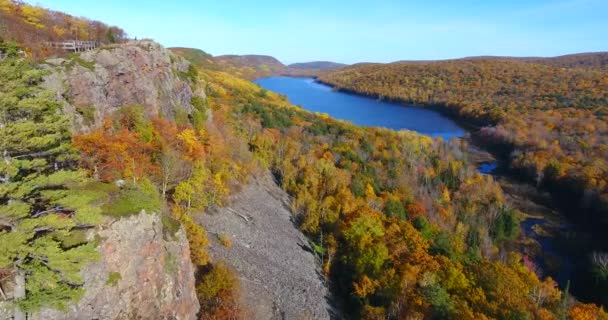 Lotnictwo nad klifami i szczytowy las jesienny w kierunku jeziora w górach — Wideo stockowe