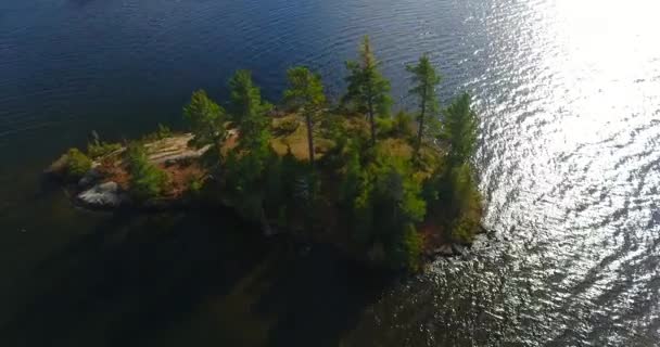 Luchtfoto cirkelen rond klein eiland op rustig meer tijdens de piek vallen — Stockvideo