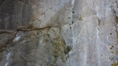 Kayalardan, mağaradan dökülen şelaleyle birlikte kanyon manzarasına doğru uçan tava.