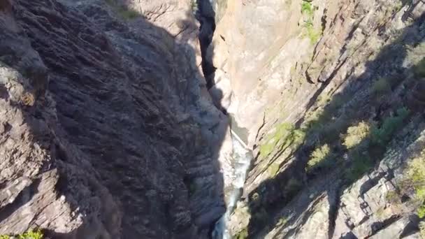 Poêle aérienne du canyon profond et de la rivière au pont piétonnier surplombant la petite ville de montagne d'Ouray, Colorado — Video