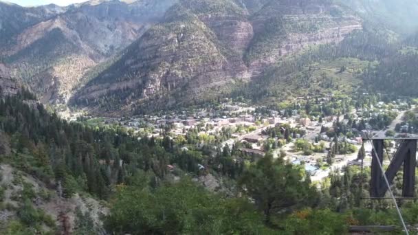 Panela aérea atrás da placa Box Canyon no topo da montanha ao lado da pequena cidade montanhosa de Ouray, Colorado — Vídeo de Stock