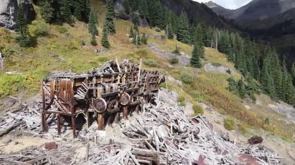 Zoom aéreo lejos de gran edificio minero abandonado escondido en el valle de la montaña — Vídeos de Stock