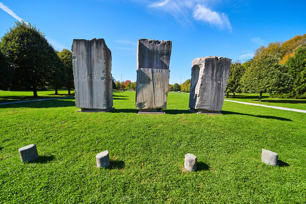 Three large stone obelisks in open green field