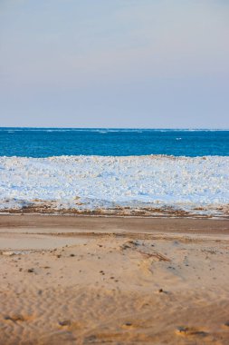 Gökyüzü, su, buz ve kum plajlarında dikey katmanlar
