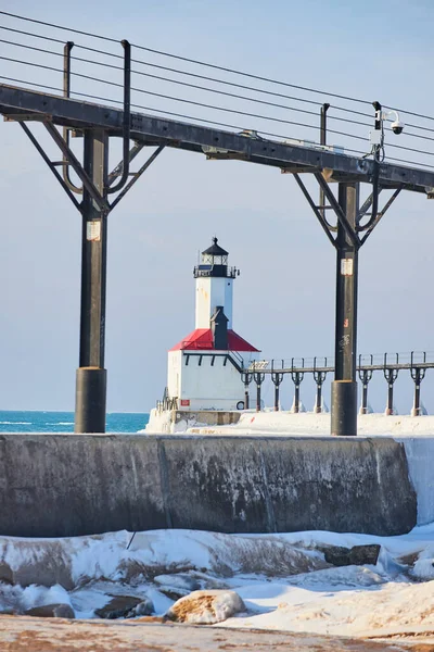 Vista verticale invernale del faro bianco e rosso sul lago Michigan attraverso ringhiera — Foto Stock