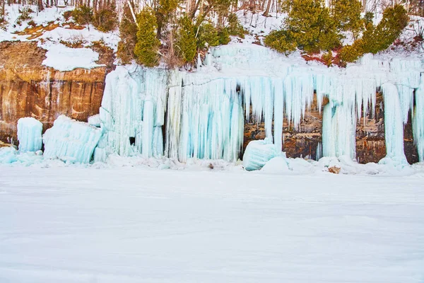 Téli sziklák a tó borított lenyűgöző kék jégképződmények — Stock Fotó