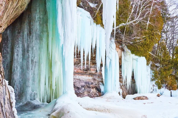 Klippen im Winter mit riesigen blauen Eiszapfen bedeckt — Stockfoto