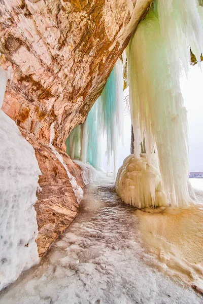 Zimowe wejście do jaskini lodowej z dużymi soplami — Zdjęcie stockowe