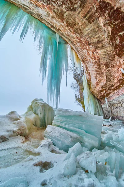Złamane olbrzymie kawałki lodu w lodowej jaskini wypełnione soplami przy wejściu — Zdjęcie stockowe