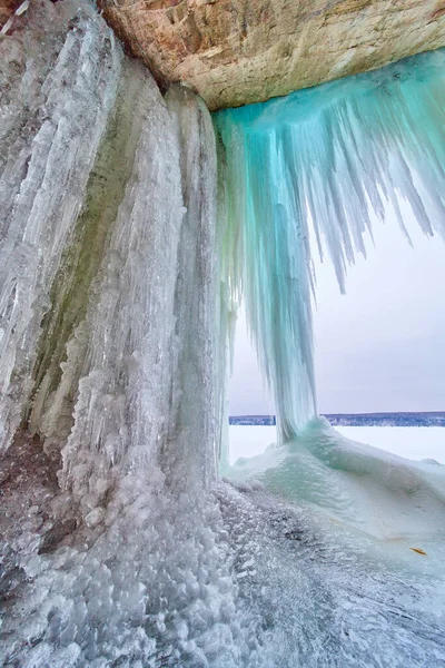 Zima niebieski ostre sople wiszące na skałach obok jeziora — Zdjęcie stockowe