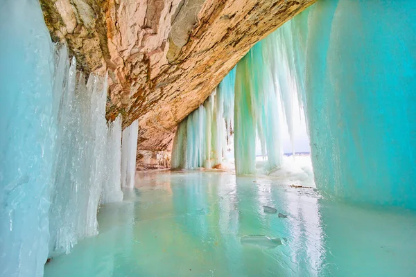 Donmuş göl ve mağara, canlı mavi ve yeşil sarkıtlar ve donmuş şelalelerle açılıyor. — Stok fotoğraf