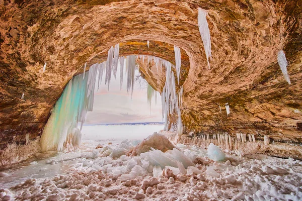 Donmuş buz mağarasının içinde donmuş göle açılan mavi ve yeşil buz saçakları ile kaplı. — Stok fotoğraf