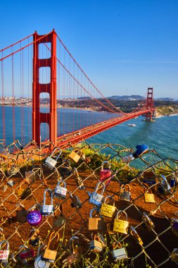 Kilitlerle kaplı tel örgülerin yanındaki Golden Gate Köprüsü 'nün resmi